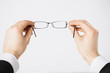 man hands holding eyeglasses
