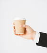 man hand holding take away coffee