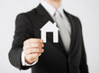 man hand holding paper house
