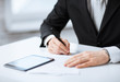 man with tablet pc signing paper