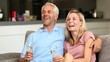 Couple watching tv while holding white wine glass