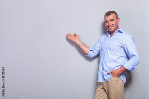 Photo: casual old man presents with hand in pocket casual old man presents with hand in pocket
