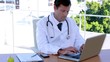 Doctor typing at his desk