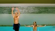 Brother and sister jumping backwards into pool