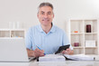 Photo: Happy Mature Man Calculating Happy Mature Man Calculating