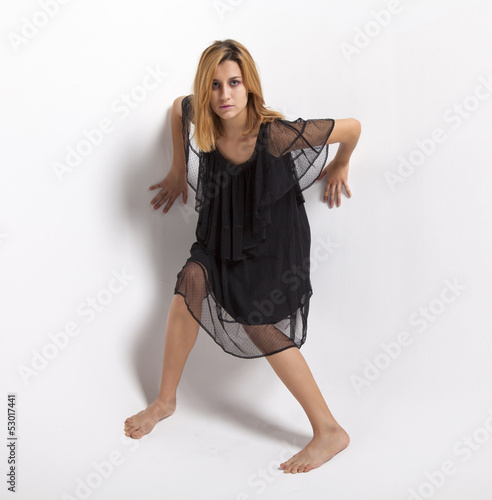 Photo: giovane ragazza in abito nero su sfondo bianco giovane ragazza in abito nero su sfondo bianco
