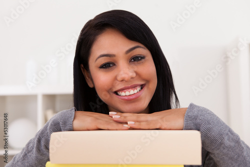 Photo: Young Woman Smiling On Stack Of Books Young Woman Smiling On Stack Of Books