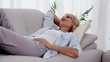 Woman smiling and relaxing on sofa