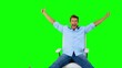 Man on swivel chair giving thumbs up on green screen