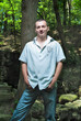 a young man is a park in the background