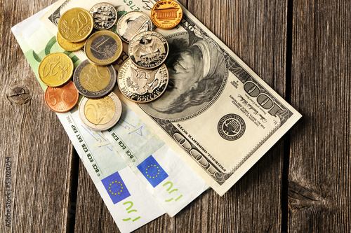Photo: US and euro money over wooden background US and euro money over wooden background