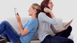 Friends sitting back to back using tablet pc