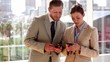 Business people chatting and looking at their phones