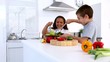 Siblings preparing salad together