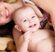 Cheerful child and beautiful mother at home.