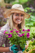 Photo: A woman is holding flowers in the garden A woman is holding flowers in the garden