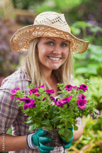Photo: A woman is holding flowers in the garden A woman is holding flowers in the garden