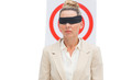 Businesswoman blindfolded in front of target