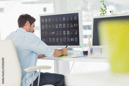 Photo: Rear view of a photo editor working Rear view of a photo editor working