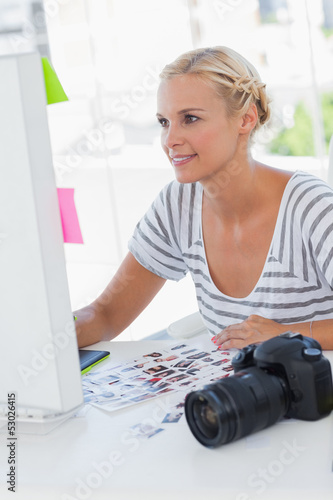 Photo: Cheerful photo editor working at her desk Cheerful photo editor working at her desk