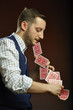 Skillful concentrated man showing a trick with playing cards