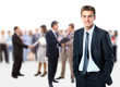 Photo: Successful business man standing with his staff in background Successful business man standing with his staff in background