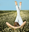 Young beautiful blond girl laying on the daisy flowers field