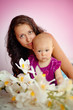 Happy family mother and her child baby girl sitting indoor and s