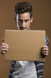 Photo: Young man holding a card board Young man holding a card board