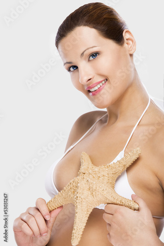 Photo: Beautiful woman holding a starfish Beautiful woman holding a starfish