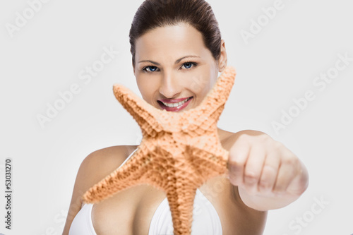 Photo: Beautiful woman holding a starfish Beautiful woman holding a starfish