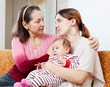 Mature mother comforts crying adult daughter