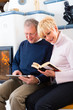 Foto: Seniors at home in front of fireplace Seniors at home in front of fireplace