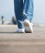 Rear view woman walking in comfortable white shoes outdoors