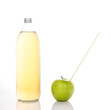 juice in a glass bottle and green apple