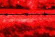 Barbed wire against a red background