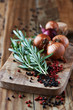 Foto: Rosemary, peppercorns and onions on chopping board Rosemary, peppercorns and onions on chopping board