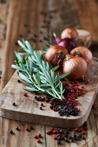 Photo: Rosemary, peppercorns and onions on chopping board Rosemary, peppercorns and onions on chopping board