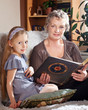 Lovely little girl  reading with her grandmother