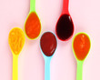 Baby puree in spoons on pink background