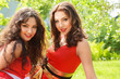 Two young women sitting on grass
