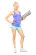 Full length portrait of a young female holding an exercising mat