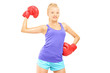 Happy female boxer with red boxing gloves posing