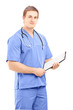 Male medical doctor in a uniform holding a clipboard and posing