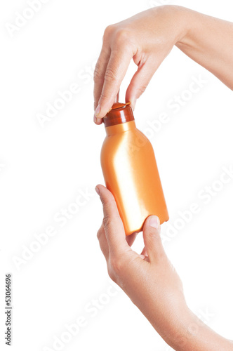 Photo: Hands holding plastic bottle for sun lotion isolated on white ba Hands holding plastic bottle for sun lotion isolated on white ba