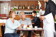 Photo: Kellner bedient Senioren im Café Kellner bedient Senioren im Café