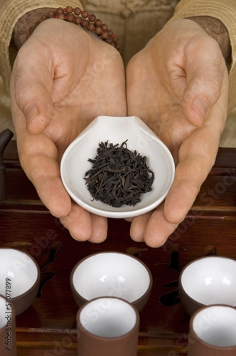 Photo: Tea in hands of tea ceremony master close up Tea in hands of tea ceremony master close up