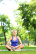 Smiling woman practicing yoga in a park
