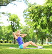 Young blond female exercising abs in a park
