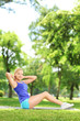 Young woman exercising on a mat in a park